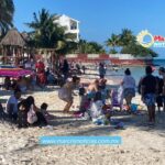 Disfrutan turistas en las playas de Cancún del Día de la Bandera